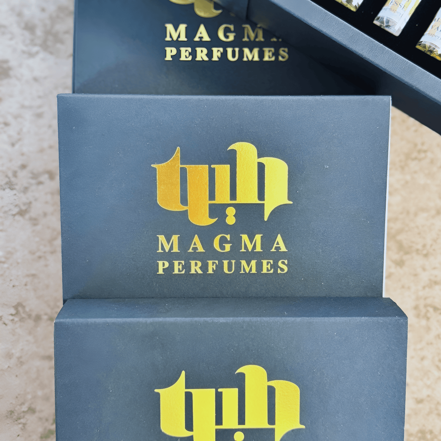 Close-up of 3ml Magma Perfumes sample vials with labels, displayed on soft background